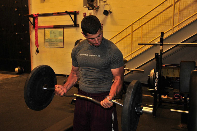Man Lifts Weights in Gym